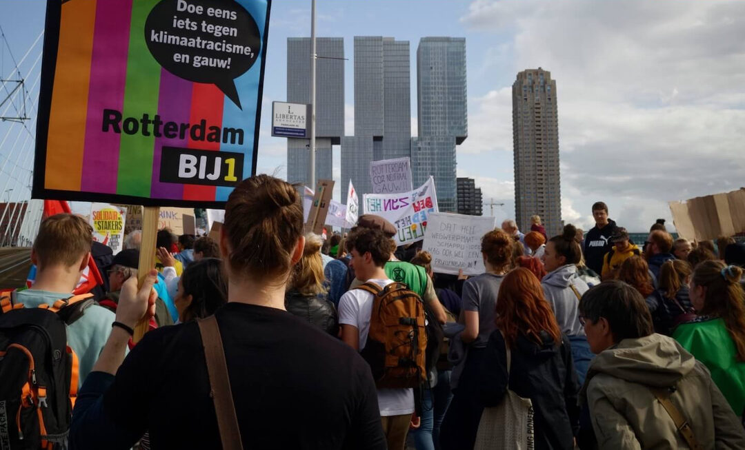 BIJ1 Rotterdam is aanwezig bij de klimaatmars. Ze houden een banner vast met de kleuren van BIJ1