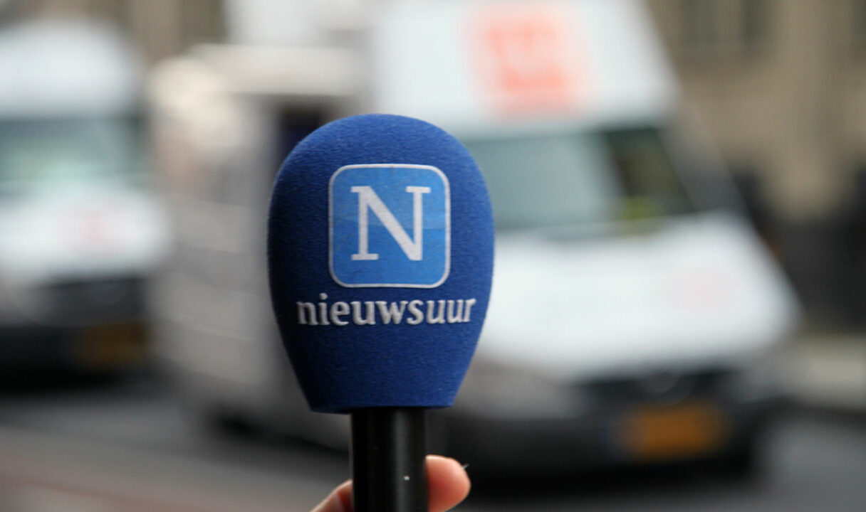 Foto van een microfoon met blauwe plopkap met het Nieuwsuur-logo erop.