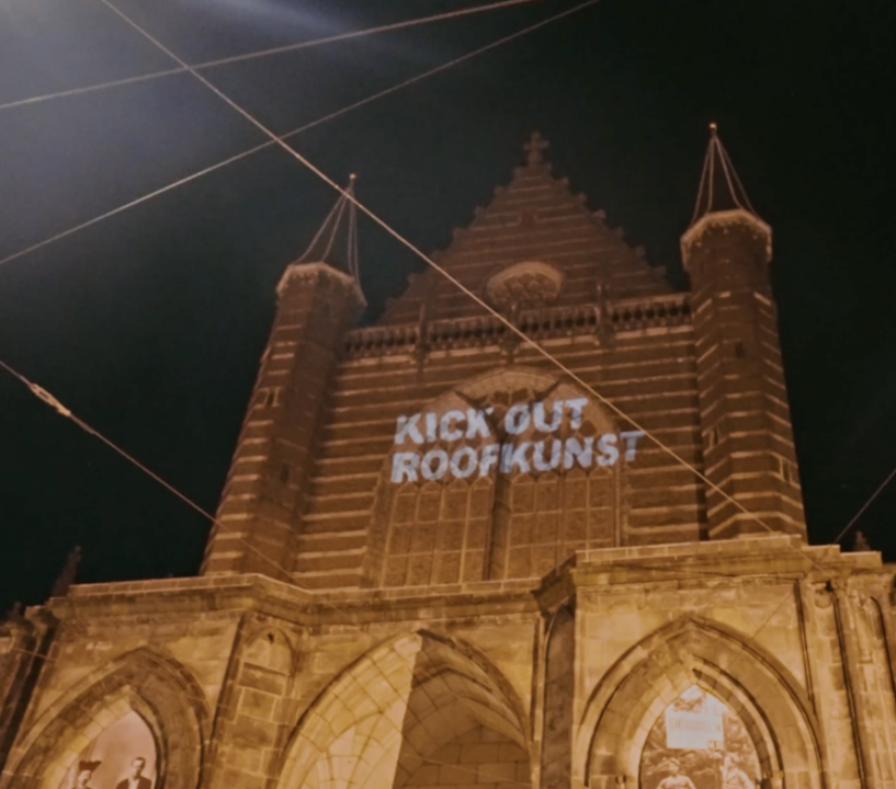 De Nieuwe Kerk in Amsterdam met daarop de tekst geprojecteerd: Kick out roofkunst