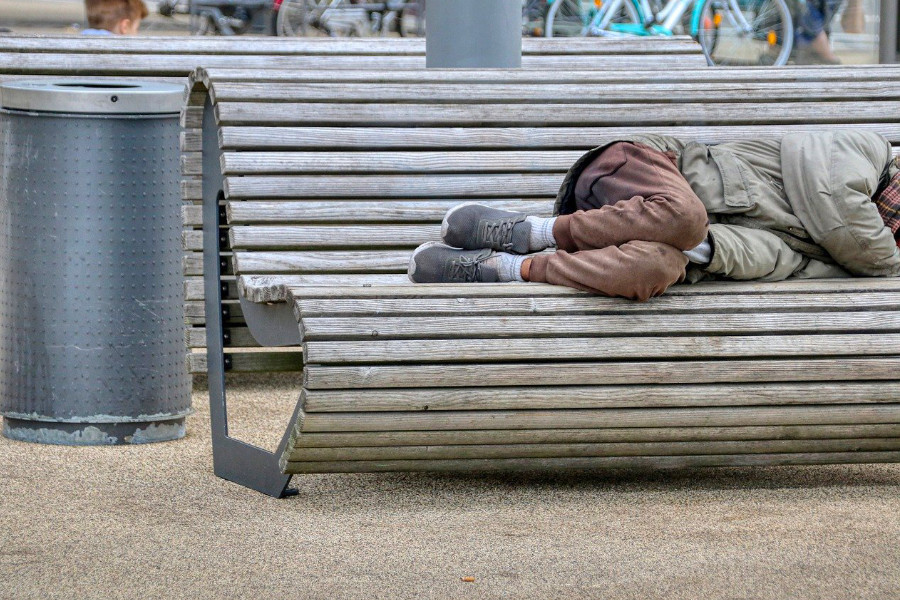 Thuisloze slaapt op een houten bank