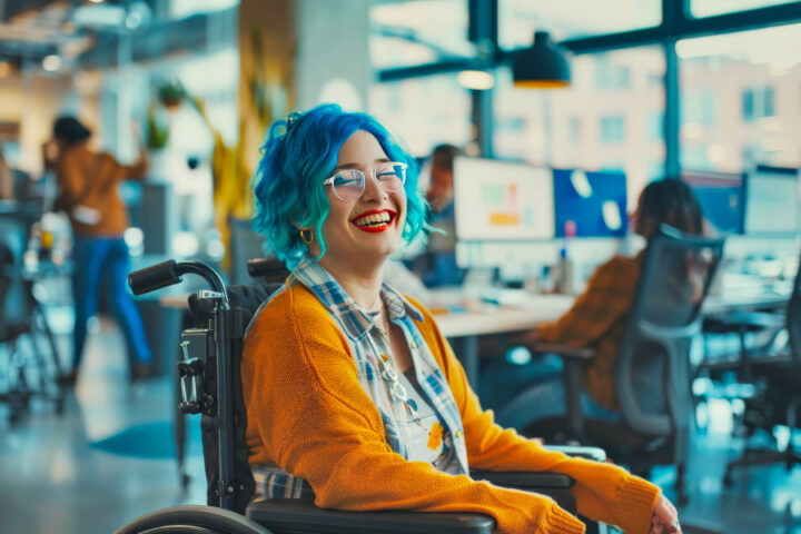 jonge vrouw met blauw geverfd haar in een rolstoel lachend