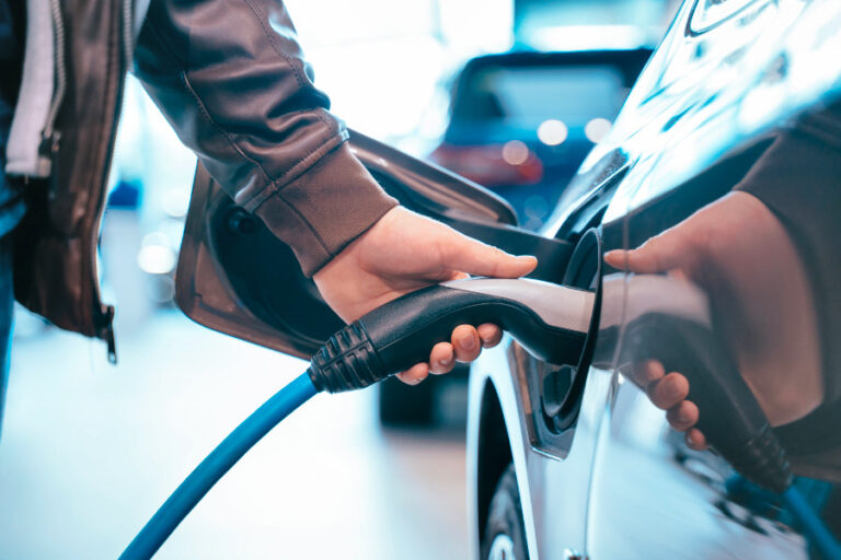 Hand houdt stekker vast van electrische auto