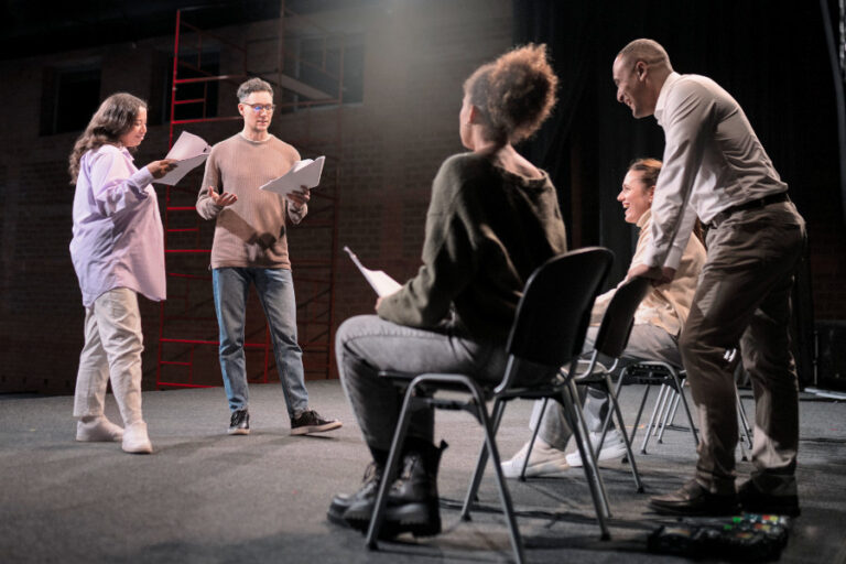 Diverse groep repeteert op podium in theaterzaal