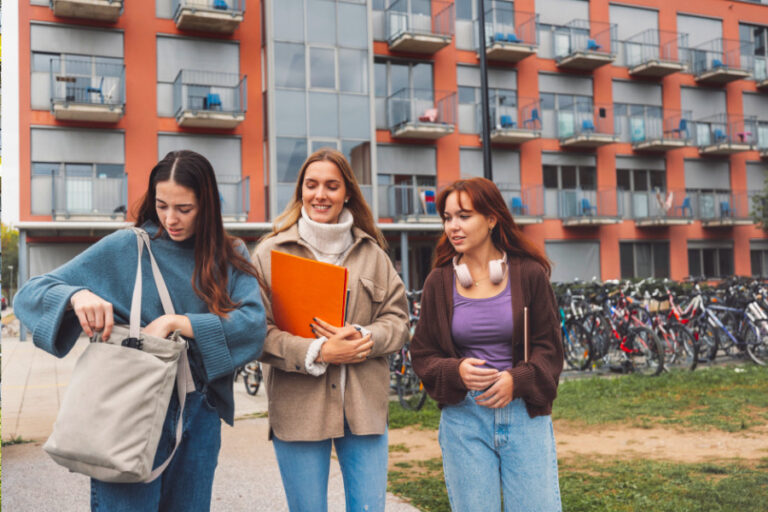 Groep jonge studentes met flatgebouw op achtergrond
